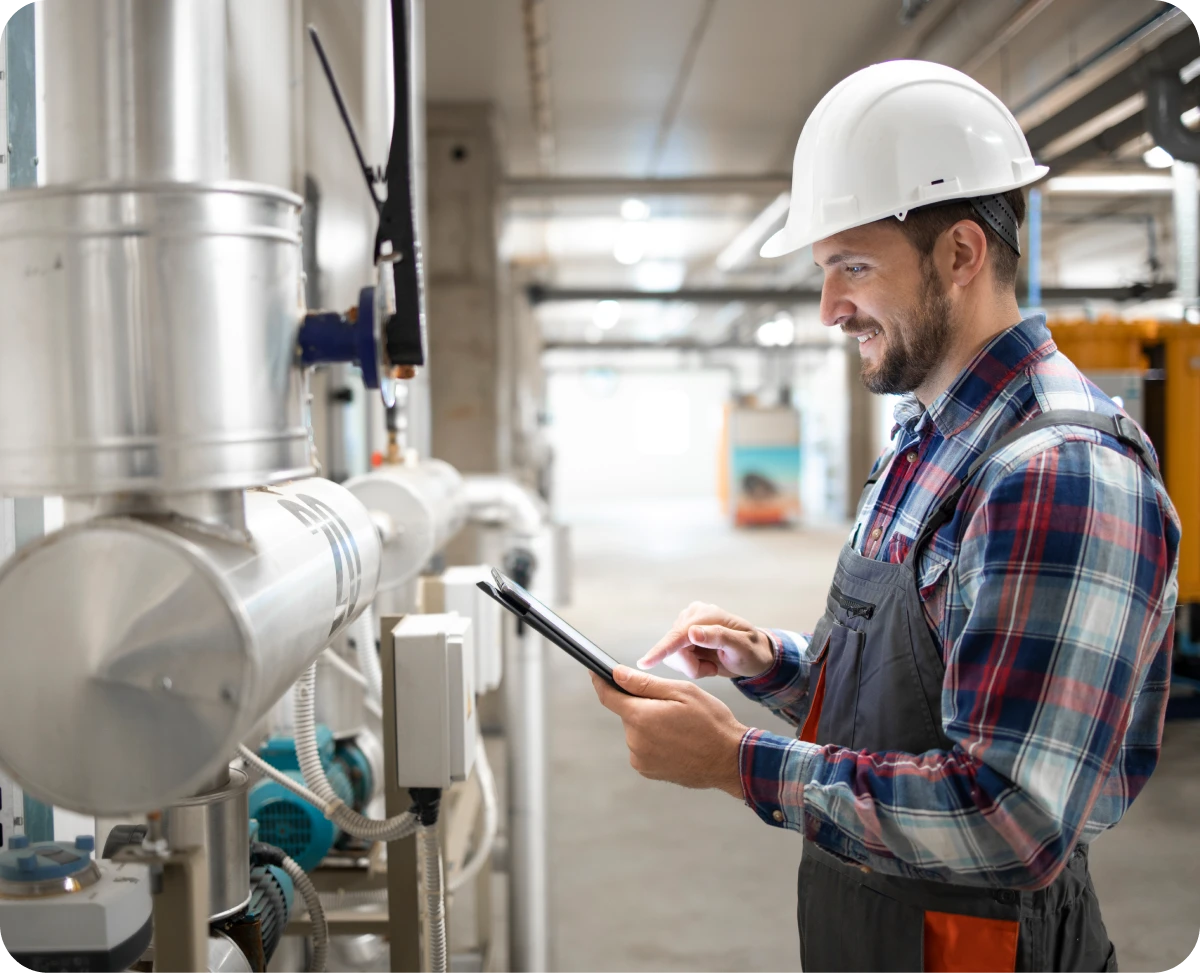 Engineer inspecting pipes with a tablet.